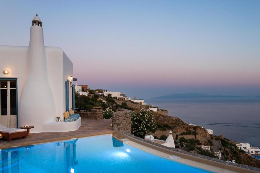 a villa with a swimming pool and a view of the ocean at AGL Luxury Villas in Psarou