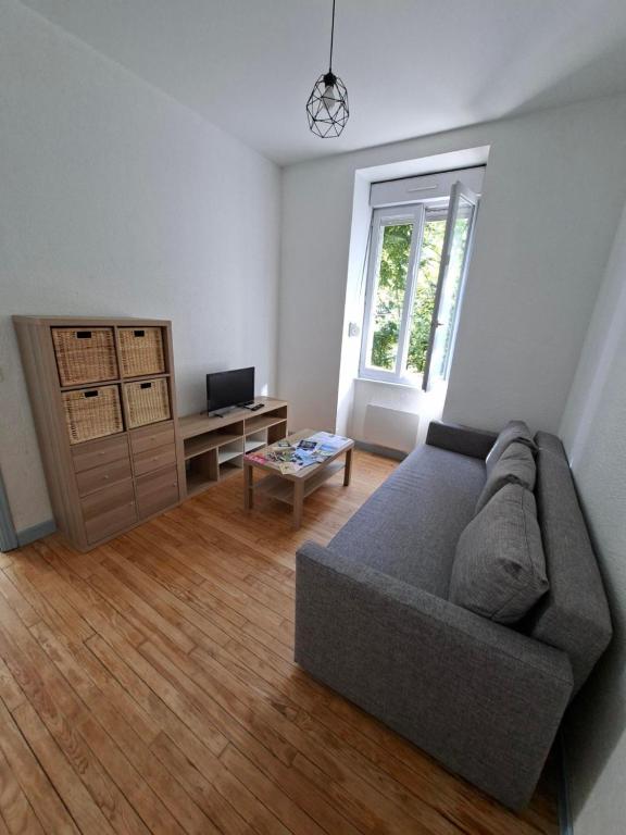 a living room with a couch and a window at Appartement avec jardin privé à 5 min du Cheylard & Dolce Via - Vacances natures, vélo & randos in Accons