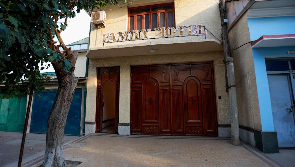 a building with two brown doors and a sign on it at Family Hotel in Khujand