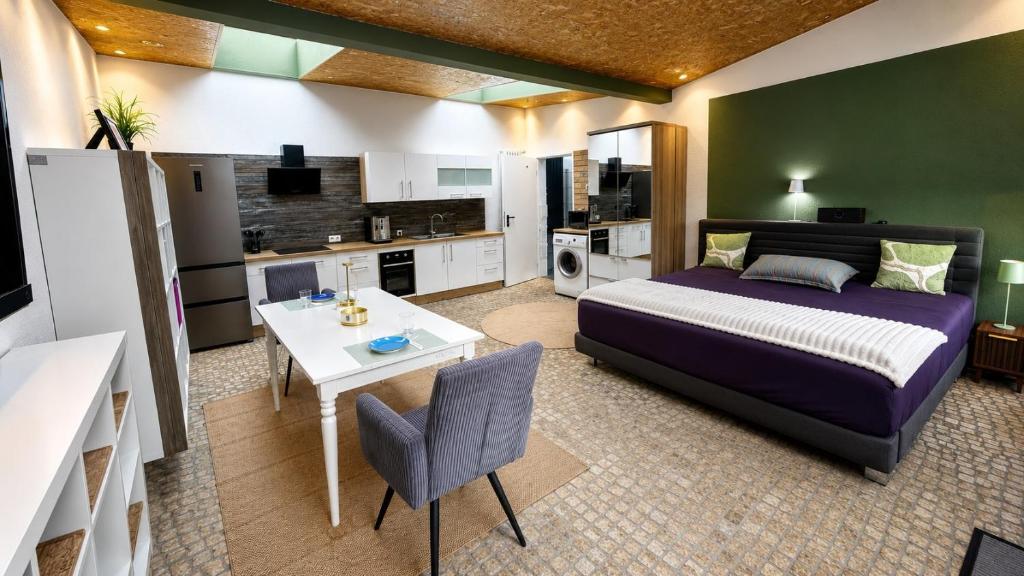 a bedroom with a bed and a table and a kitchen at Apartment 202 in Bernau bei Berlin