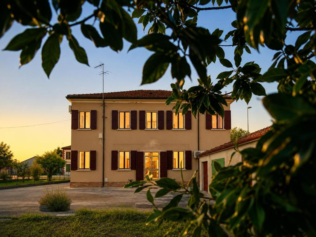 a building with the sun shining on it at Ca'Mia - Rooms in Porto Tolle