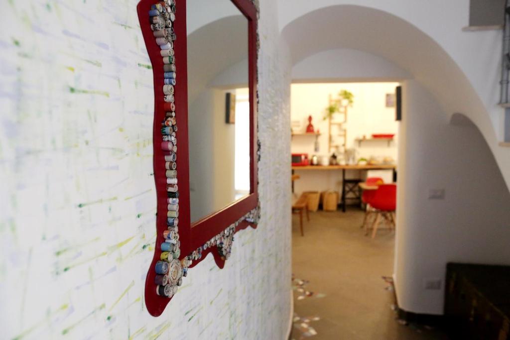 einen Spiegel an einer Wand in einem Zimmer in der Unterkunft B&B Alchimia Napoletana in Neapel