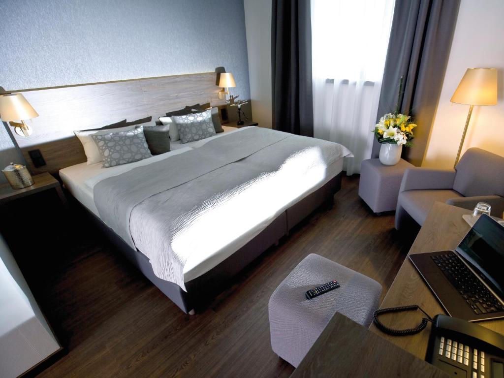 アイスリンゲンにあるHotel Eislinger Torの大きなベッドとデスクが備わるホテルルームです。