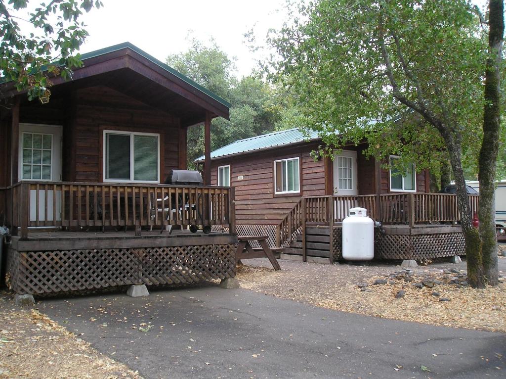 ein Blockhaus mit einer Veranda und einer Bank vor dem Haus in der Unterkunft Russian River Camping Resort Studio Cabin 4 in Cloverdale