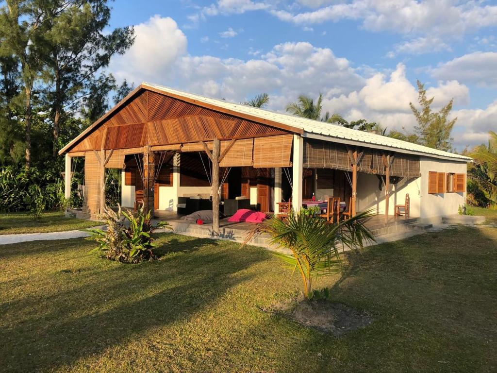 a house with a gambrel roof on a yard at Villa Masoandro in Sainte Marie