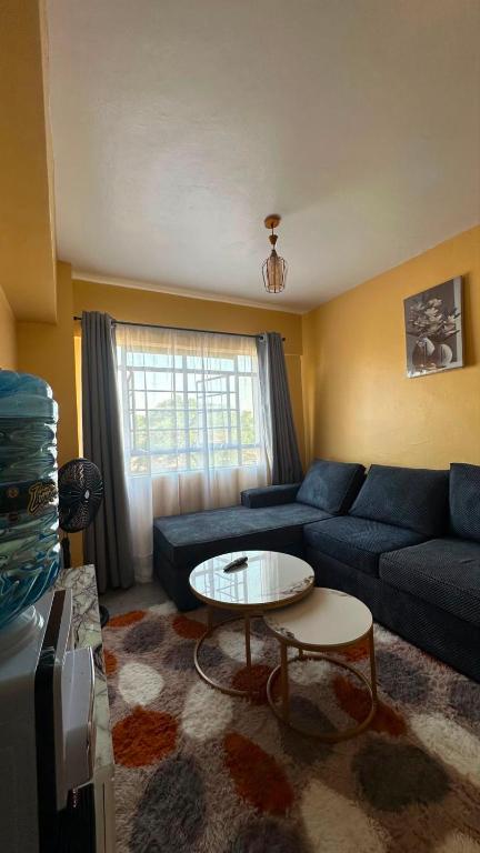 a living room with a blue couch and a table at Lucci suites in Kisumu