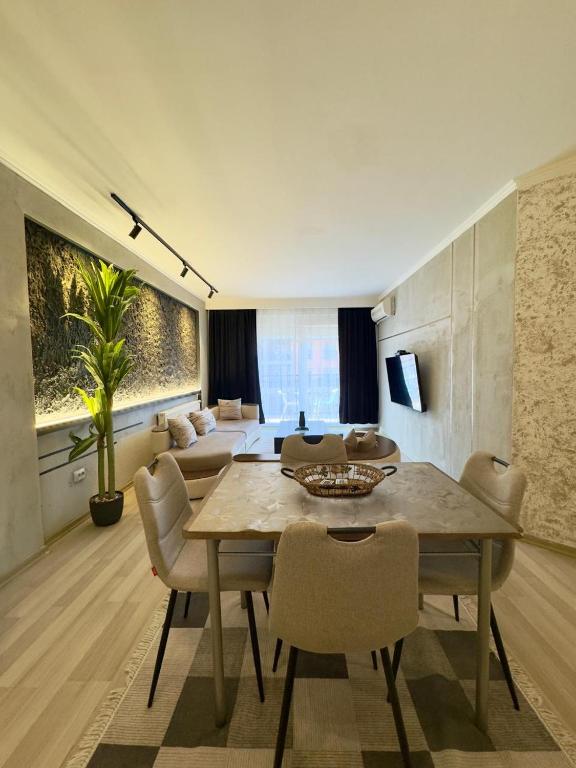 a living room with a table and chairs and a couch at Prishtina Escape Apartments - Luxury & Modern Apartment in Prishtinë