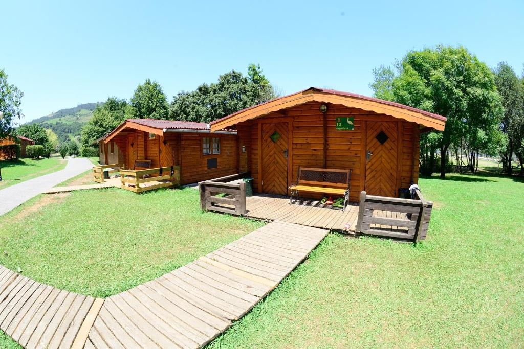 un par de cabañas de madera en un parque en Albergue Finca El Mazo, en Rada