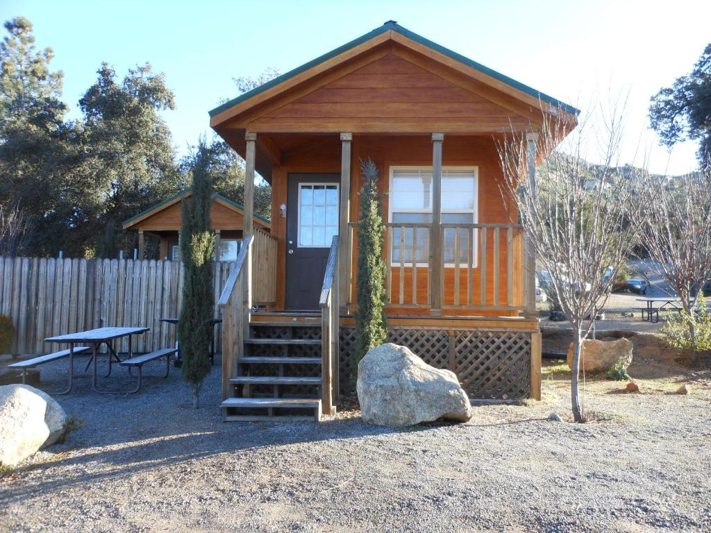 a small wooden cabin with a bench and a table at Oakzanita Springs Camping Resort Cabin 1 in Descanso