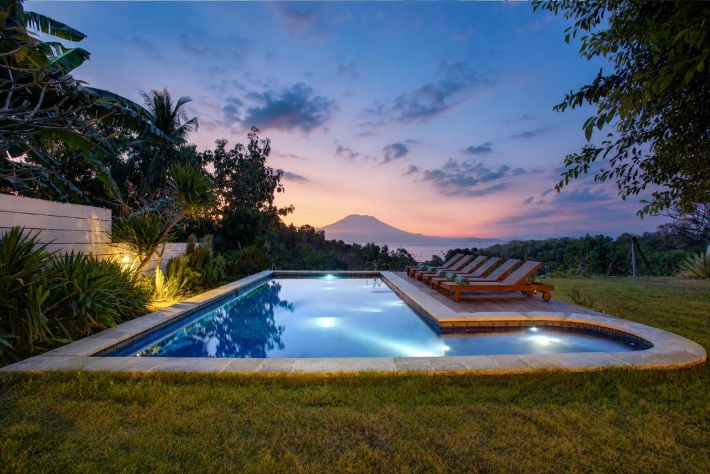 a swimming pool in the yard with a bench at Villa Panorama in Nusa Penida