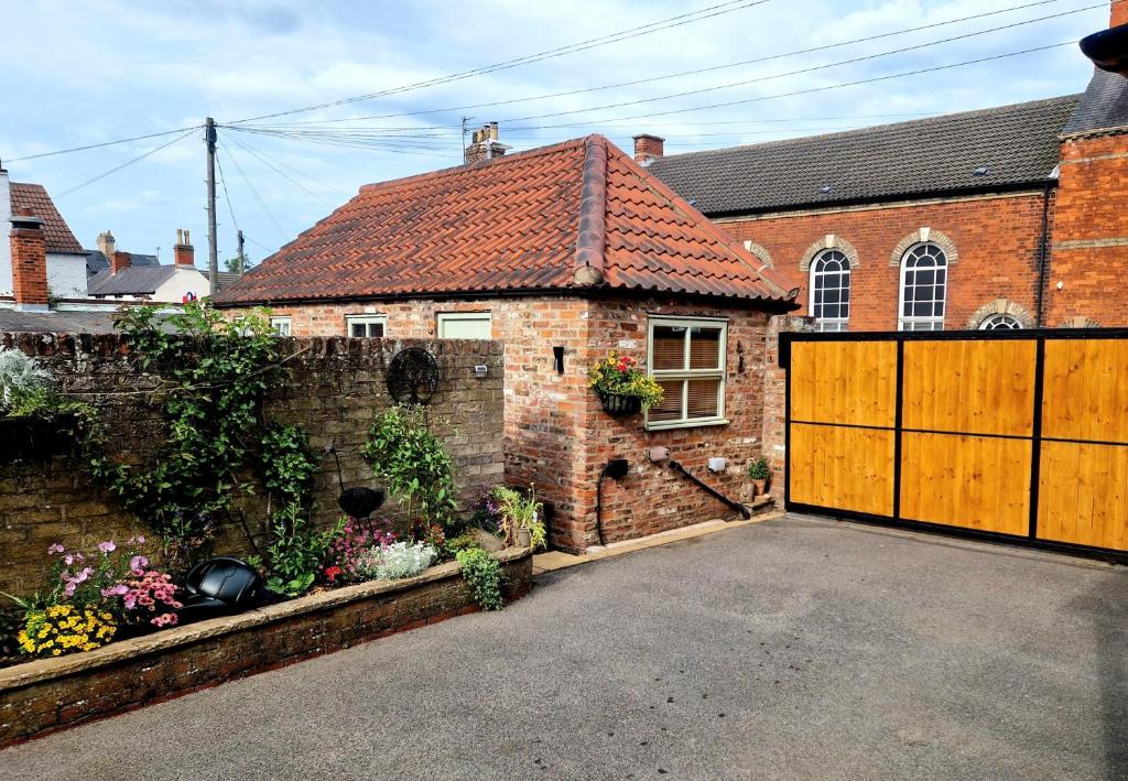 a brick house with a wooden garage door at The Stables Annexe in Patrington