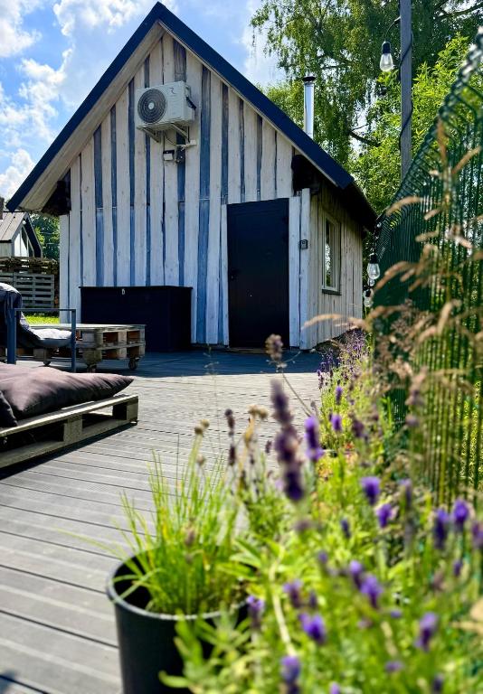 a barn with a porch and flowers in front of it at Stodoła in Nieledwia