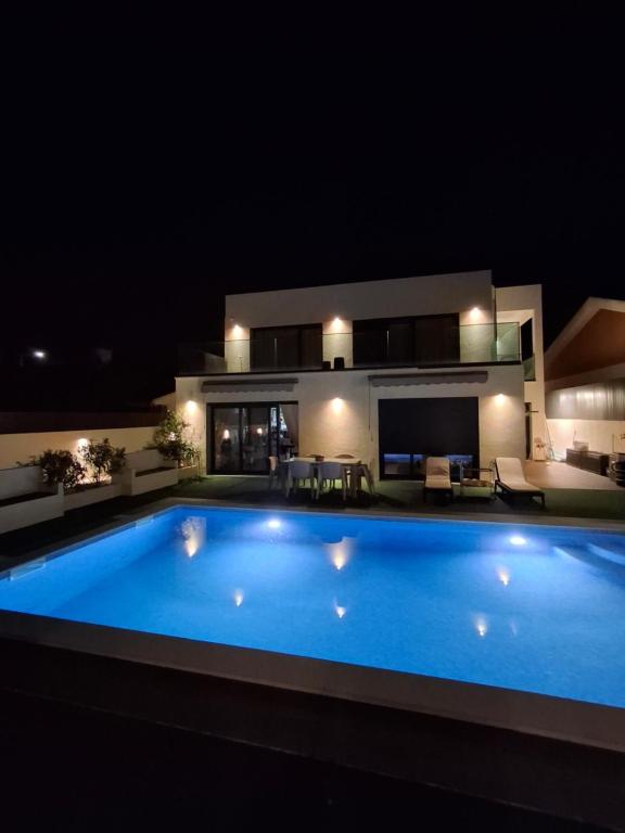 a large swimming pool in front of a house at night at RM MAISON by Rui & Mi in Tomar