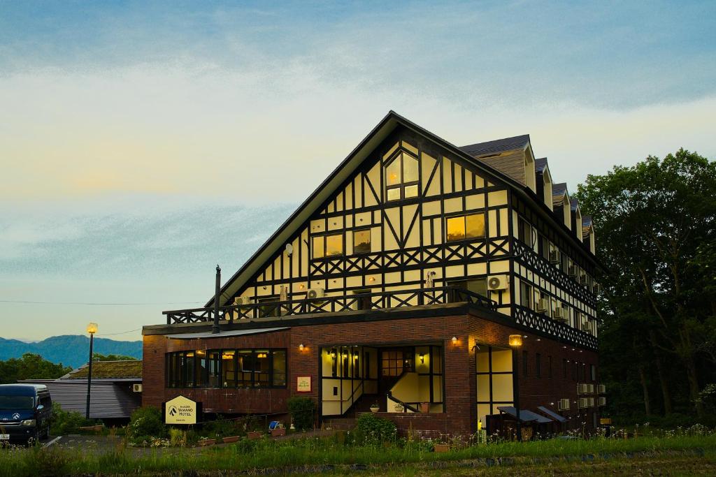 a large house with a gambrel roof at Hakuba Yamano Hotel in Hakuba