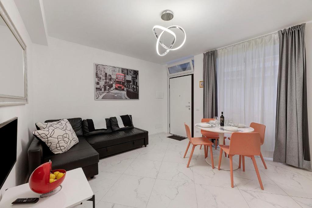 a living room with a black couch and a table at Casa Sole Porlezza in Porlezza