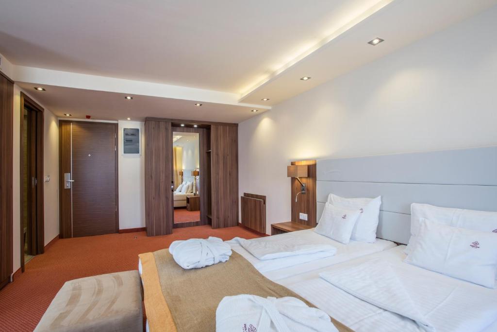 a hotel room with two beds with white pillows at Bükkös Hotel & Spa in Szentendre