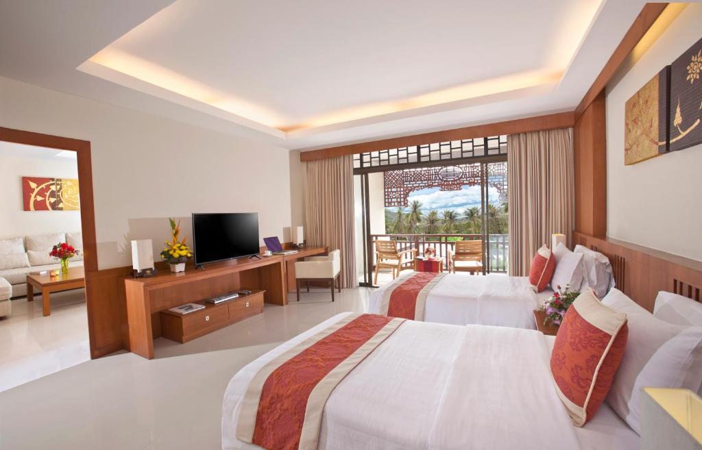 a hotel room with two beds and a television at Le Murraya Boutique Serviced Residence & Resort in Chaweng