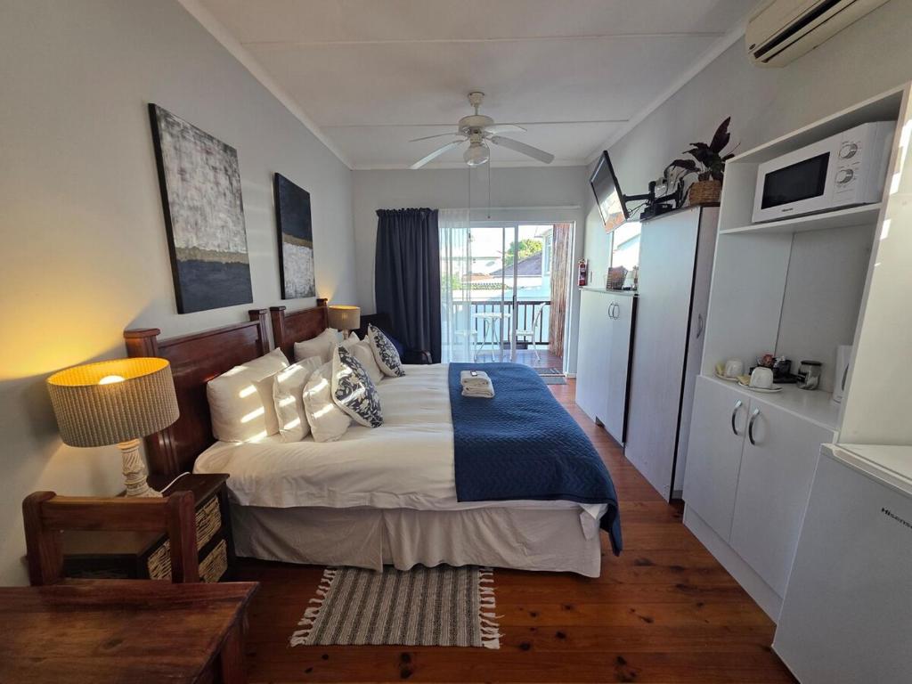 a bedroom with a bed with a blue comforter at Deck Room with Neighborhood view in Bunkers Hill