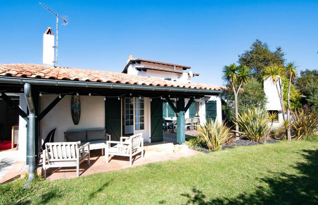 a house with two chairs on a patio at Villa des Landes - Seignosse - Jacuzzi in Seignosse