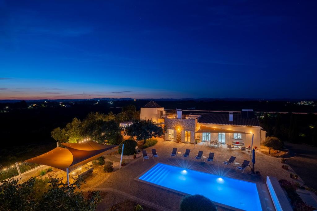 a villa with a swimming pool at night at Dois Moinhos Do Vento, Santo Estevão in Santo Estêvão