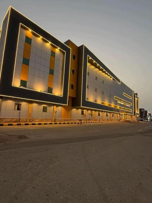 a large building with lights on the side of it at شقق ليالي الشاطئ in Al Qunfudhah