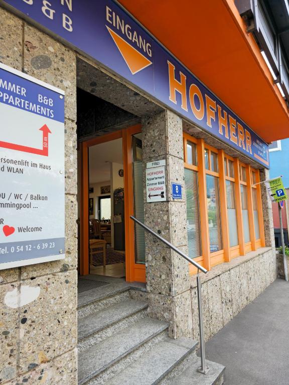 a hotel building with an orange door and a sign at Appartement Simone Hofherr in Imst