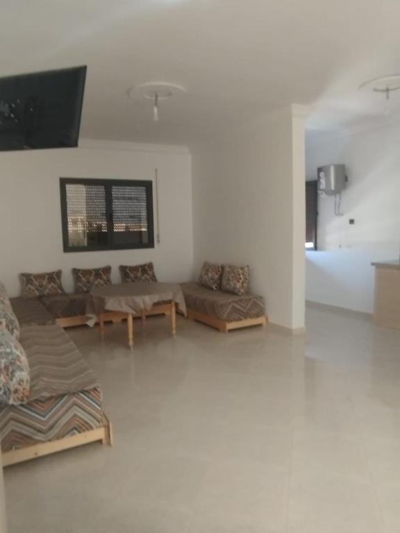 a living room with couches and a flat screen tv at Résidence Maya 1 près de la plage in Ras El Ma