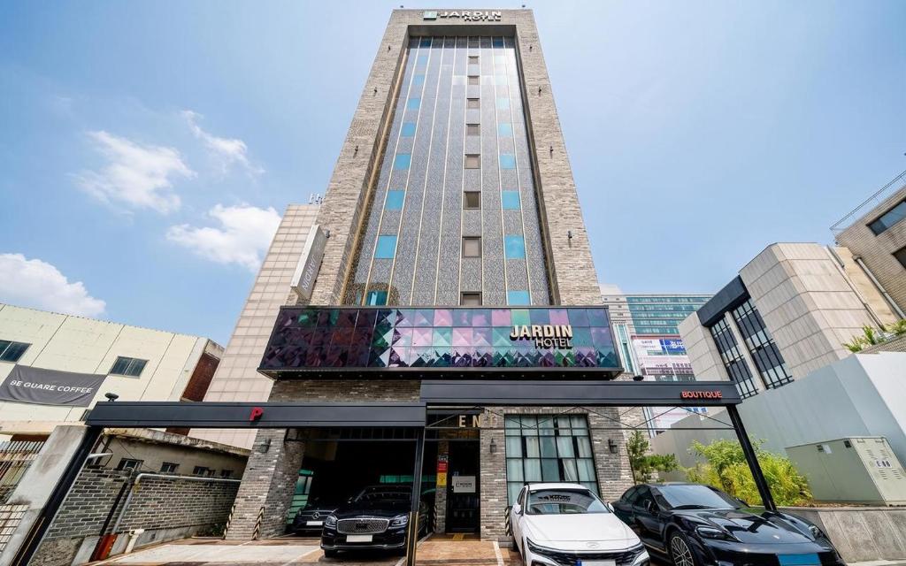 a tall building with cars parked in front of it at Jardin Hotel in Seoul