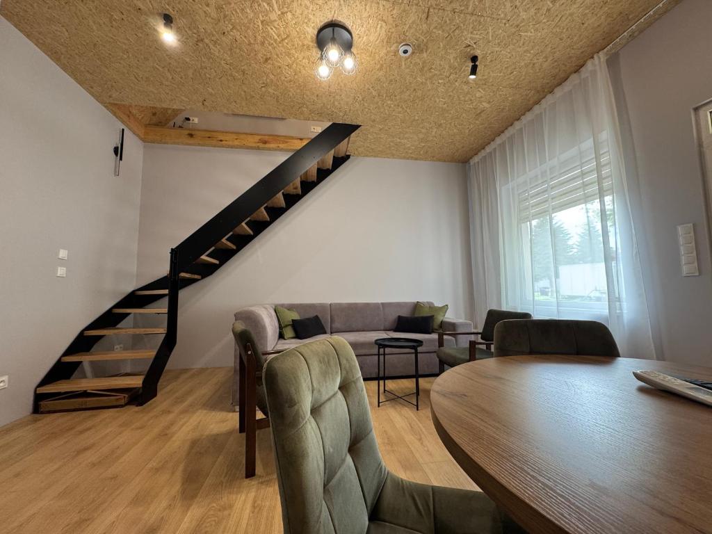 a living room with a wooden table and a staircase at Apartament Zbąszynek in Zbąszynek
