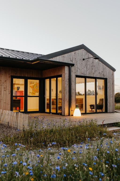 a house with windows and a field of flowers at Les Ecuries du bout du monde in Landunvez
