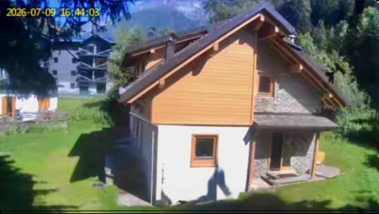 ein Hausmodell mit einer Person, die davor entlanggeht in der Unterkunft Chalet Angelo in Ponte di Legno