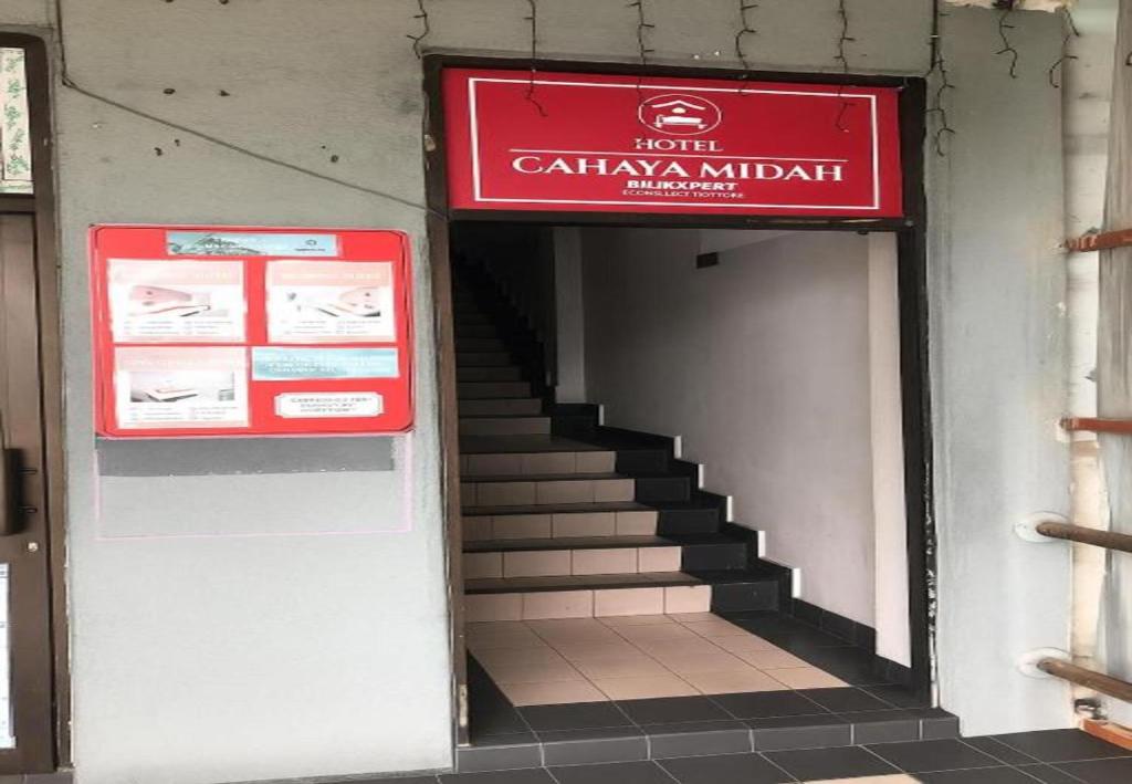 a stairway with a red sign and a staircase with a stairwayaughaugh at Cahaya Midah Hotel (BilikXpert) in Kuala Lumpur