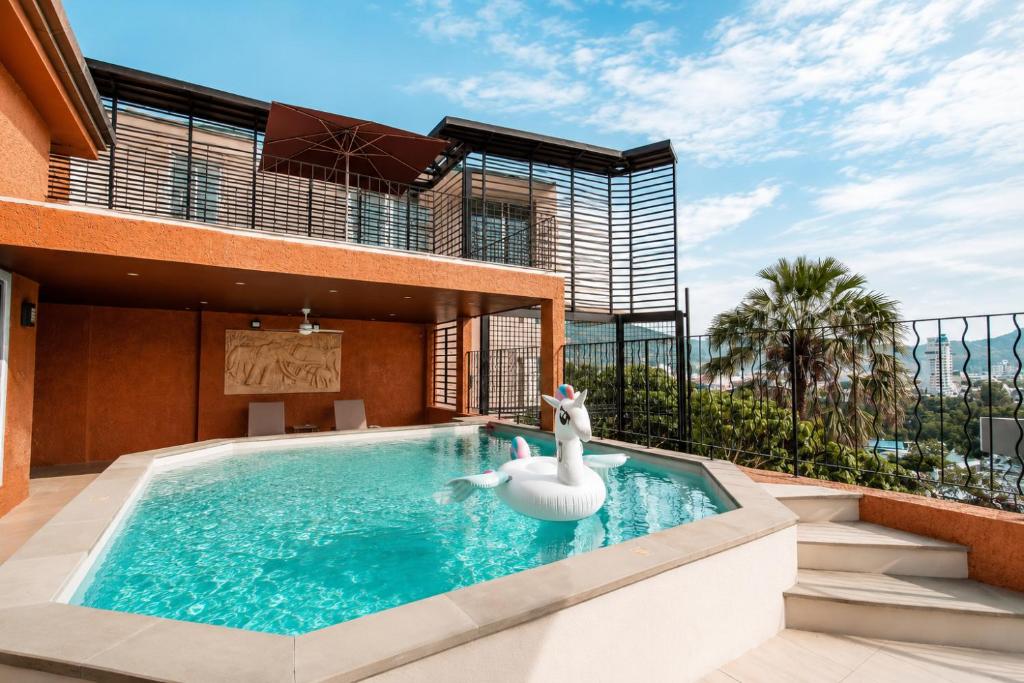 a swimming pool with a swan in a house at Teetara Villa Patong in Patong Beach