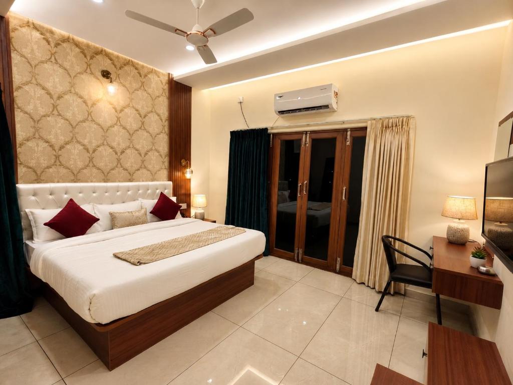 a bedroom with a large bed and a desk and a bed sidx sidx sidx sidx at Sree Durga Hotel Ramsons International in Mysore