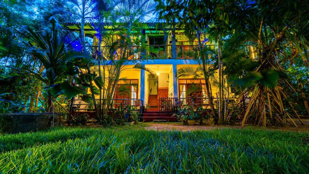 a house in the middle of a yard with trees at N S K Green Villa in Sigiriya