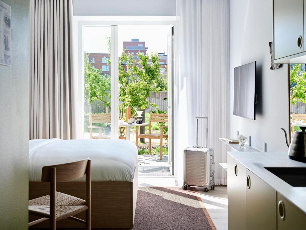 a hotel room with a bed and a large window at Folk Copenhagen in Copenhagen