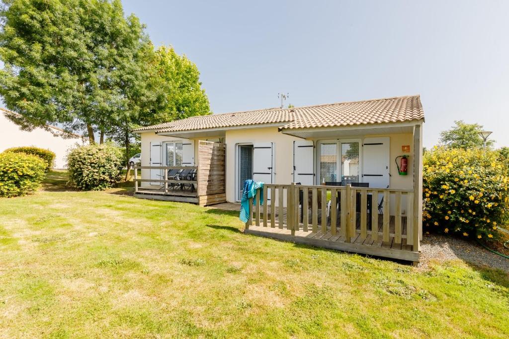 a small house with a porch and a yard at 11 - Le Rossignol - Village vacances in Maché