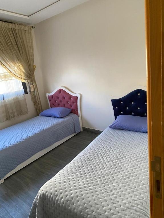 a bedroom with two beds and a window at Appartement 1 in Al Hoceïma