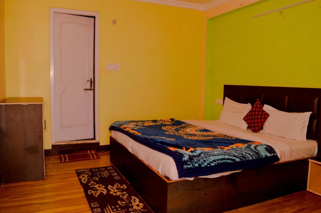 a bedroom with a bed in a room with green walls at Hotel Annapurna in Dharamshala