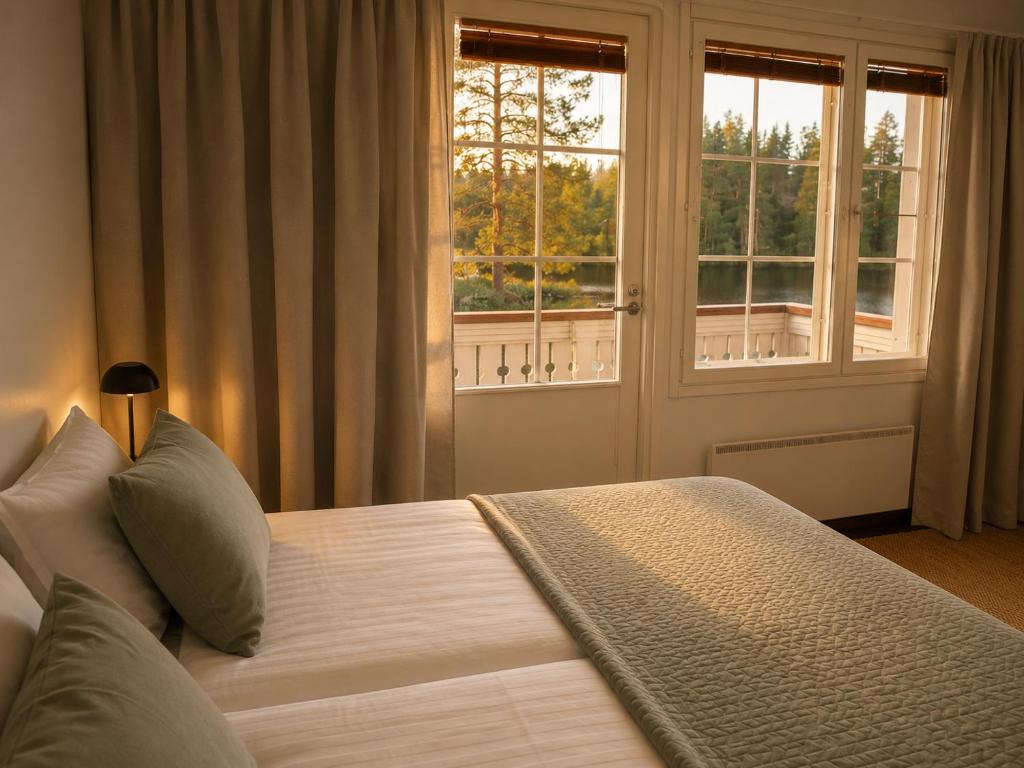 a bedroom with a large bed with a window at Aldeia Bianca Lake Resort & Italian Restaurant in Kerimäki