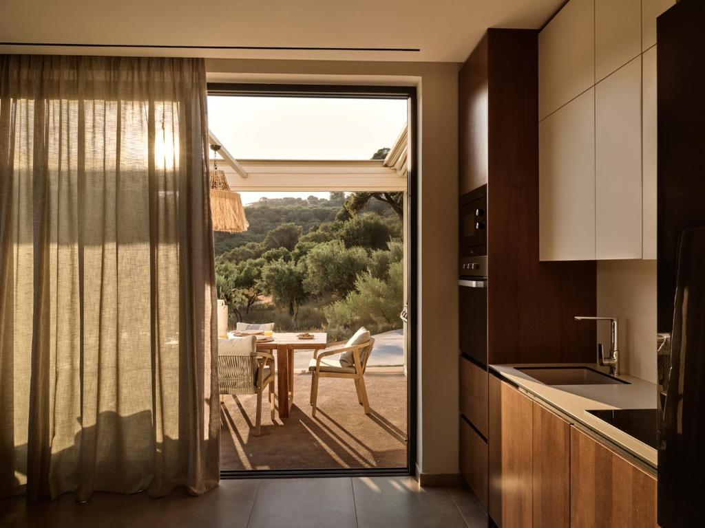 a kitchen with a sliding glass door to a patio at Villa Theta by Villa Select in Kalamaki
