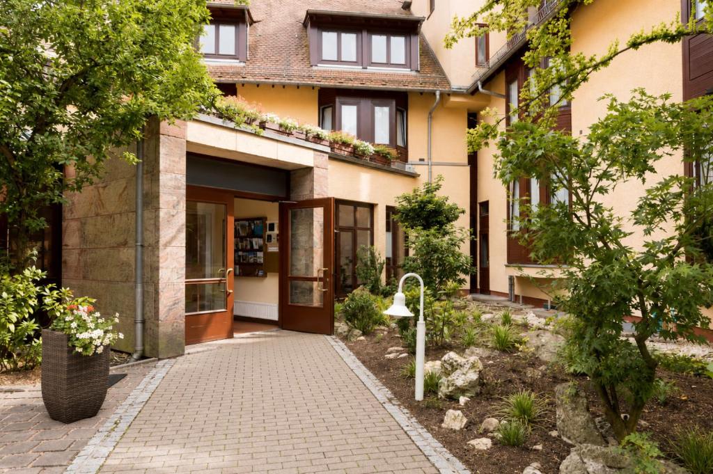 a building with a walkway in front of it at Sunday Hotel Nürnberg in Nuremberg