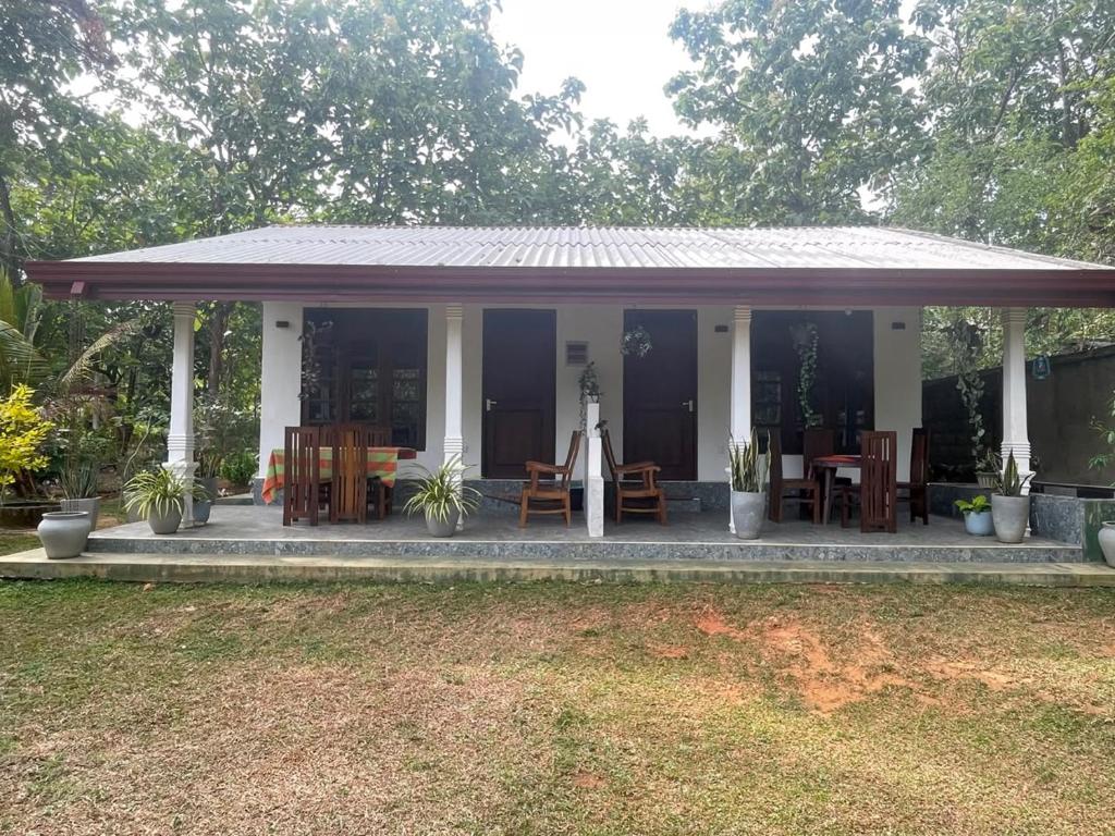 a house with a porch with tables and chairs at Sigiri Thaniya Villa in Sigiriya