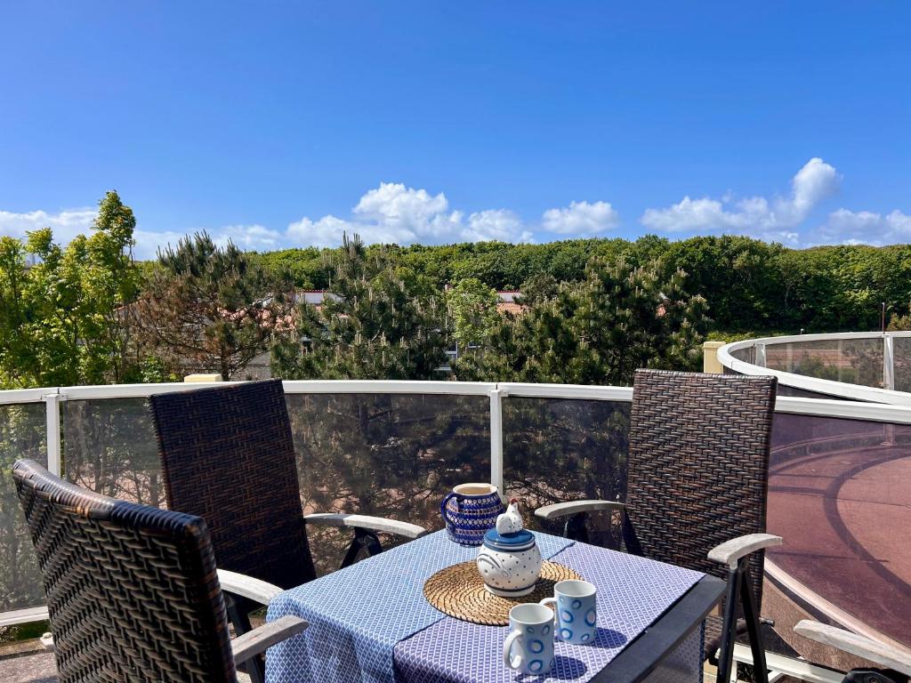 a table and chairs on a balcony with a view at De Strandloper in Julianadorp