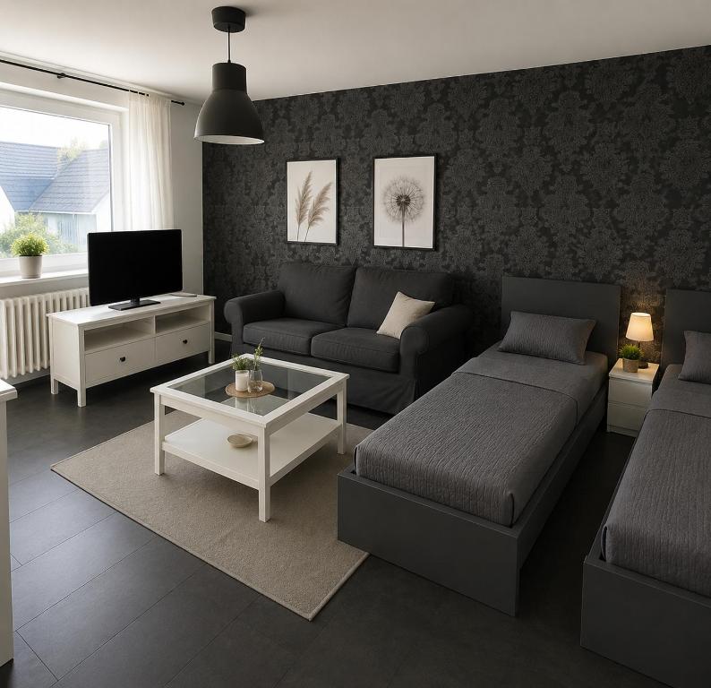 a living room with a couch and a tv at Pulheim Living 3 in Pulheim