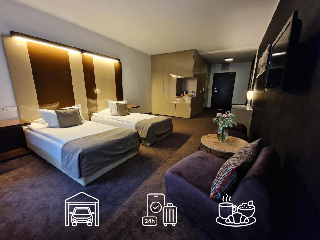 a hotel room with two beds and a couch at Platinum Apartments Aparthotel in Poznań