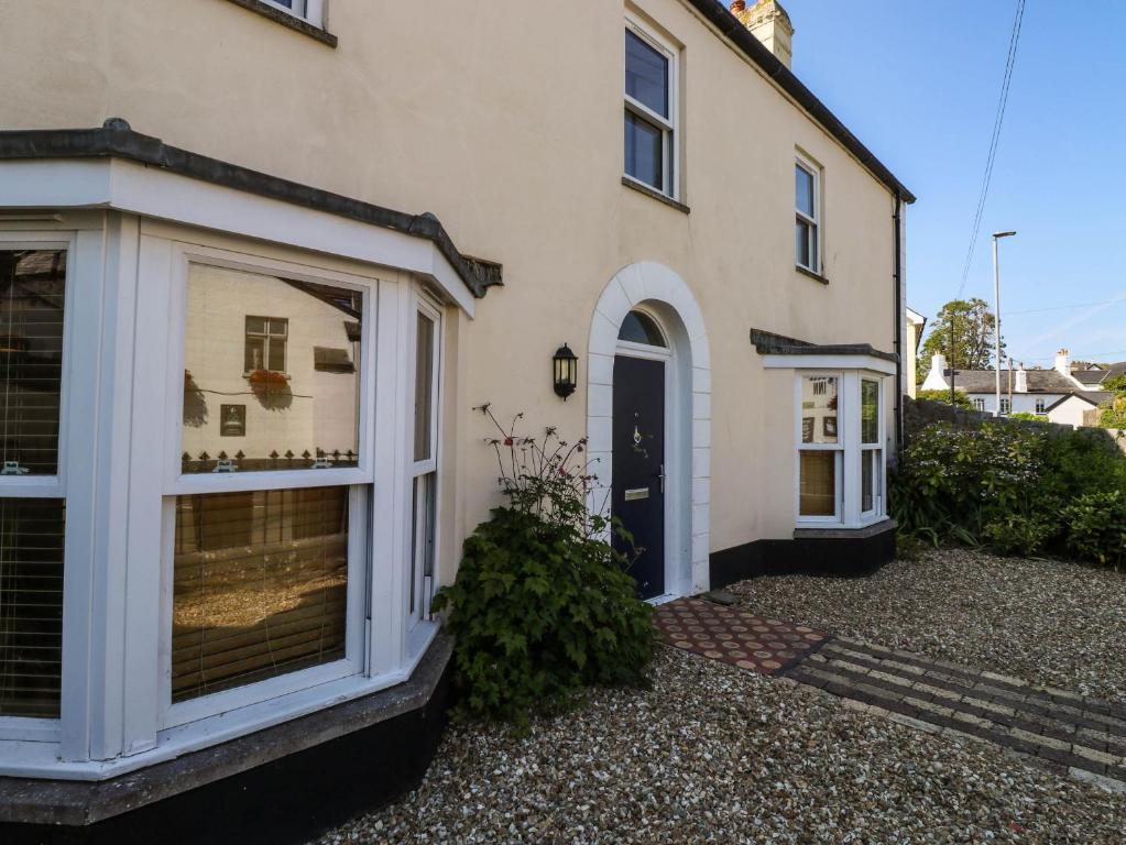 a white house with a window and a door at Flat 1 in Newton Abbot