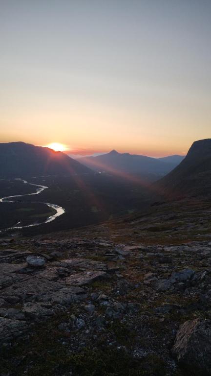 a sunset over a valley with a river and mountains at Reisa River Lodge in Potka