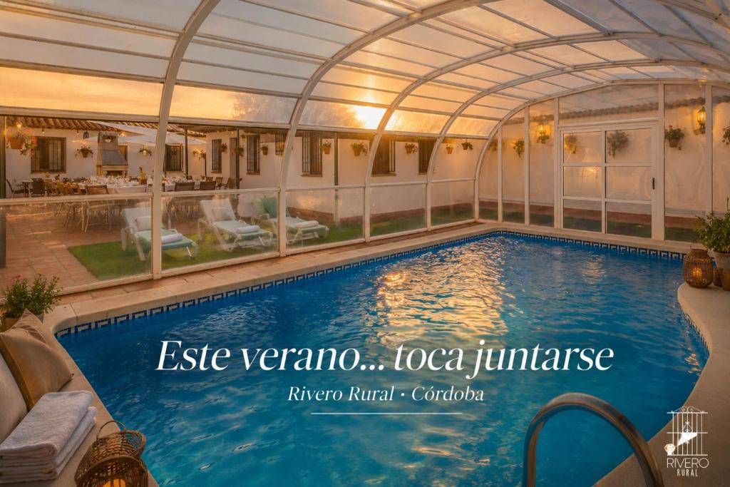 a large swimming pool with an arcade over it at Rivero Rural Casa Rural para Grupos y Familias en Córdoba in Posadas