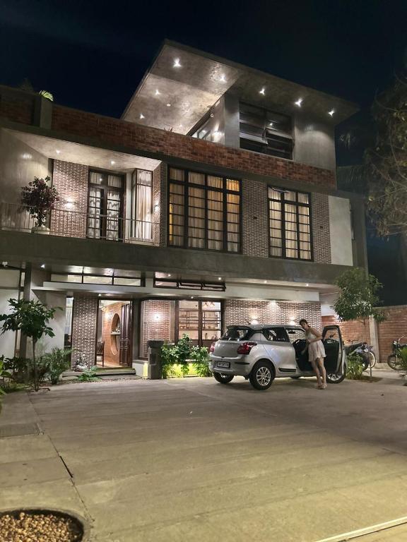 a man standing next to a car in front of a building at Savana Luxury Stay in Pondicherry